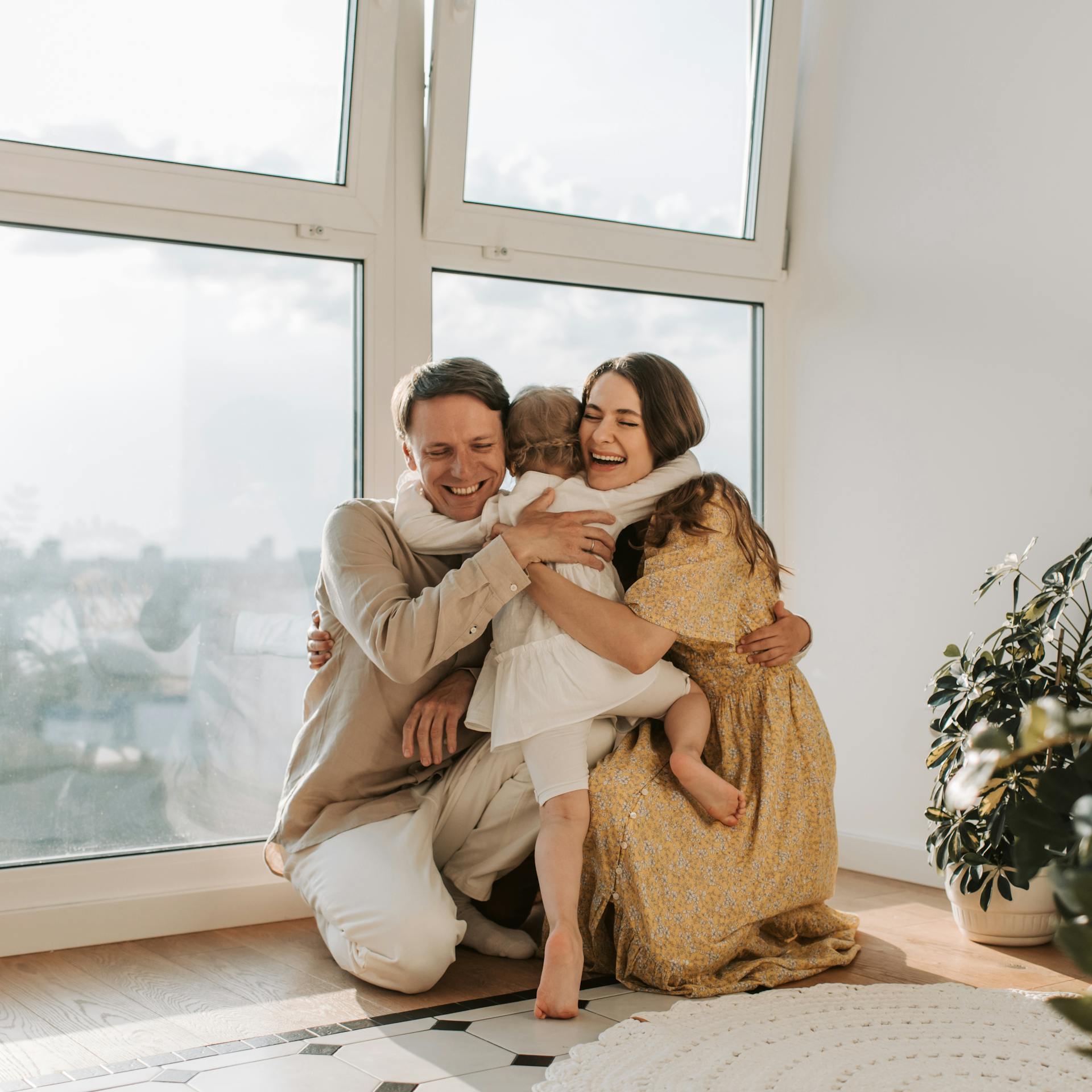 Family with one child in the living room at home smiling and laughing together